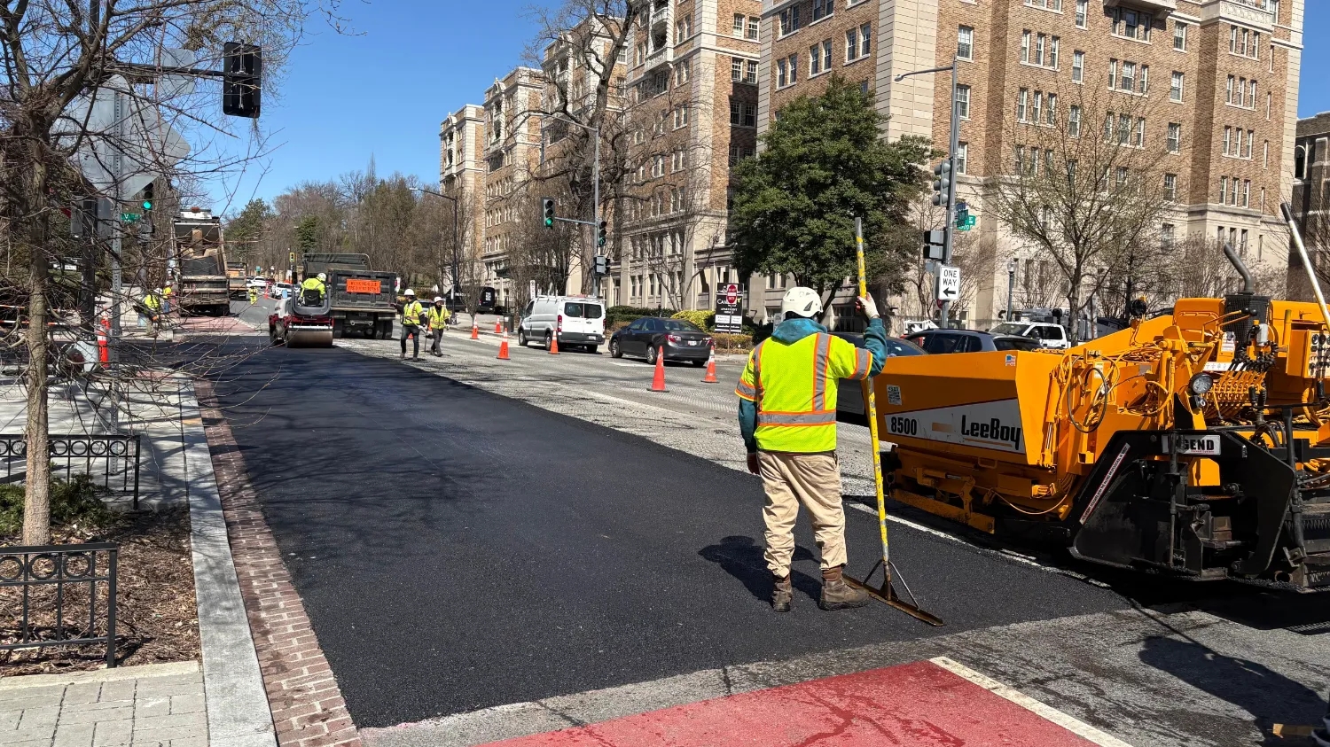 A road crew is using heavy machinery to repave a city street.